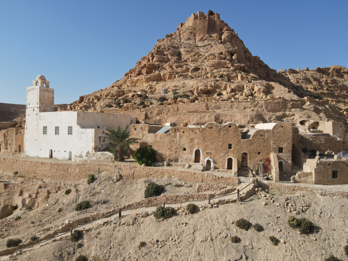 Ksar Douiret and its surroundings. Jemaa Al Nakhla mosque is the white building to the left with Ksar Douiret visible on the hill in the background. Photo Credit: ASOR.